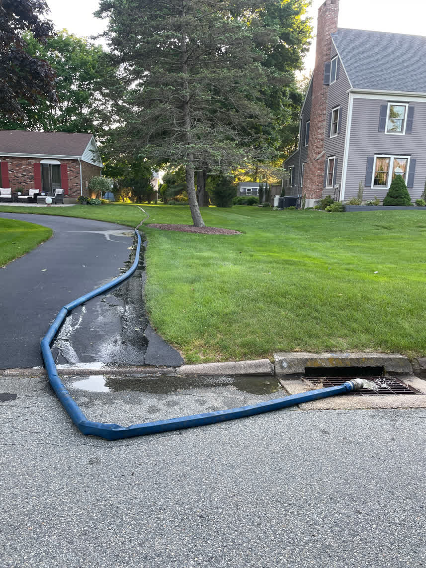 Here is a hose running from the backyard of this home to the pool draining the water.