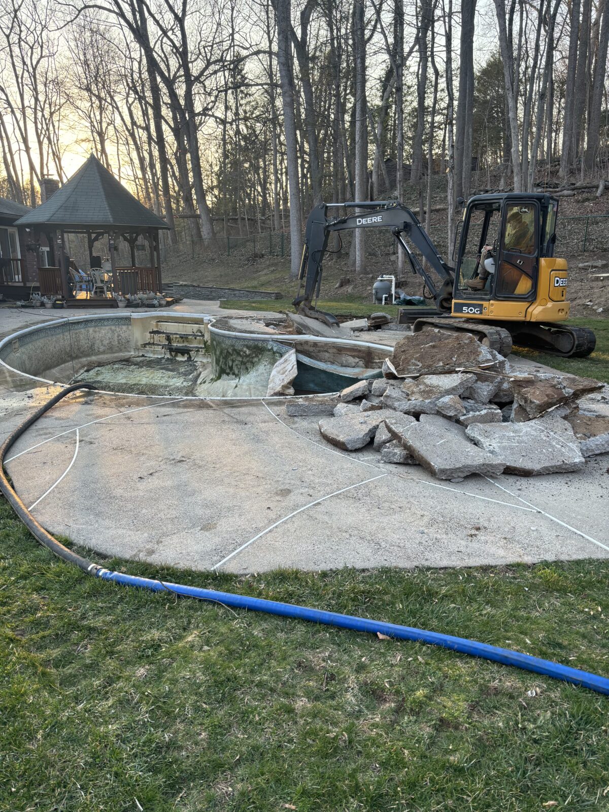 Beginning process of pool removal using an excavator. Pool removal North Branford CT