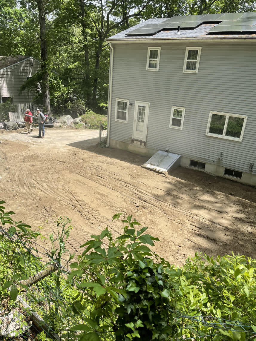 Backside of house where pool use to be located in the dirt area.