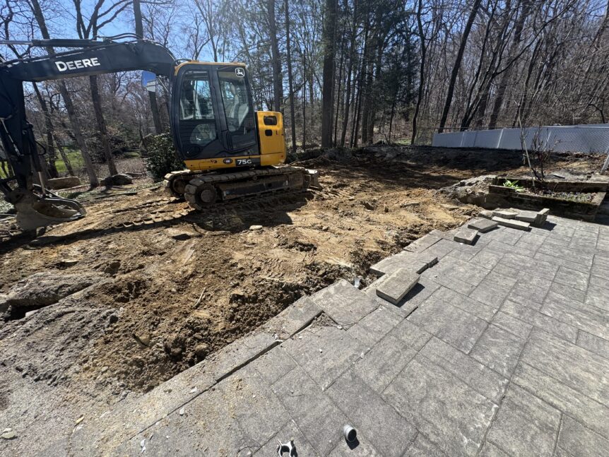 excavator grading dirt where swimming pool was