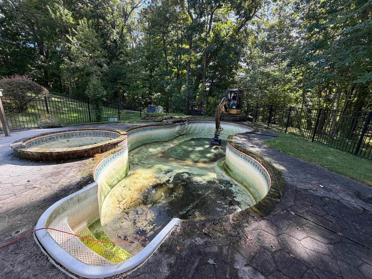 Drained pool and excavator before removal in Guilford, Connecticut